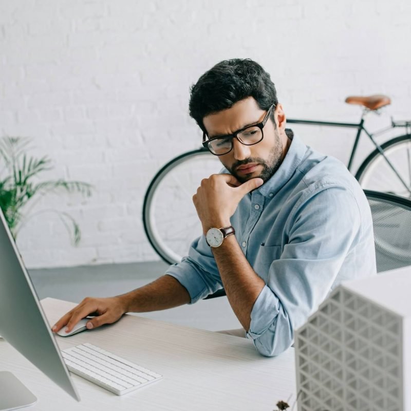 serious-handsome-architect-using-computer-and-looking-at-architecture-model-in-office.jpg
